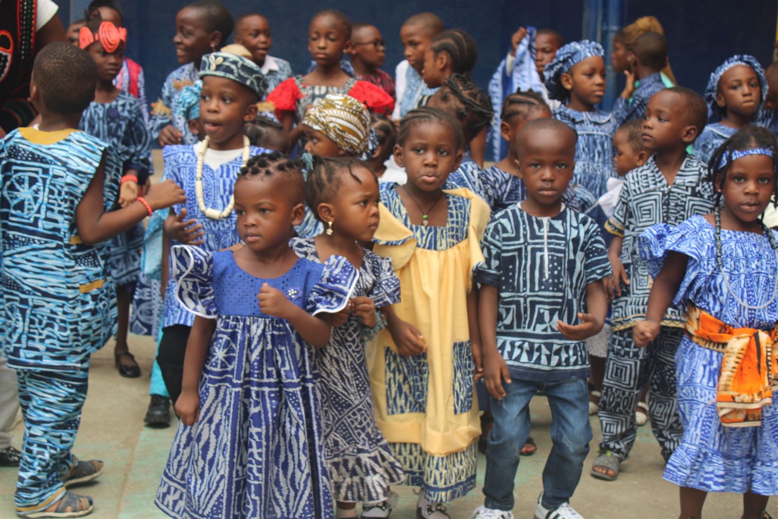 Enfants de maternelle en costumes traditionnels bleus dans la cour de l'école