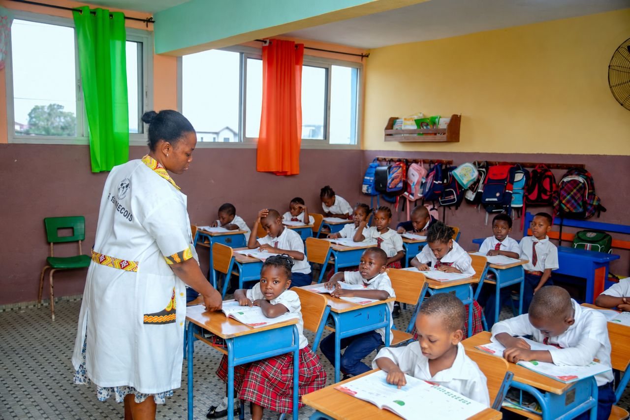 Enseignante avec des élèves de primaire en pleine activité de classe